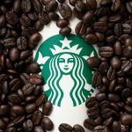 A cup of Starbuck coffee with coffee beans background
